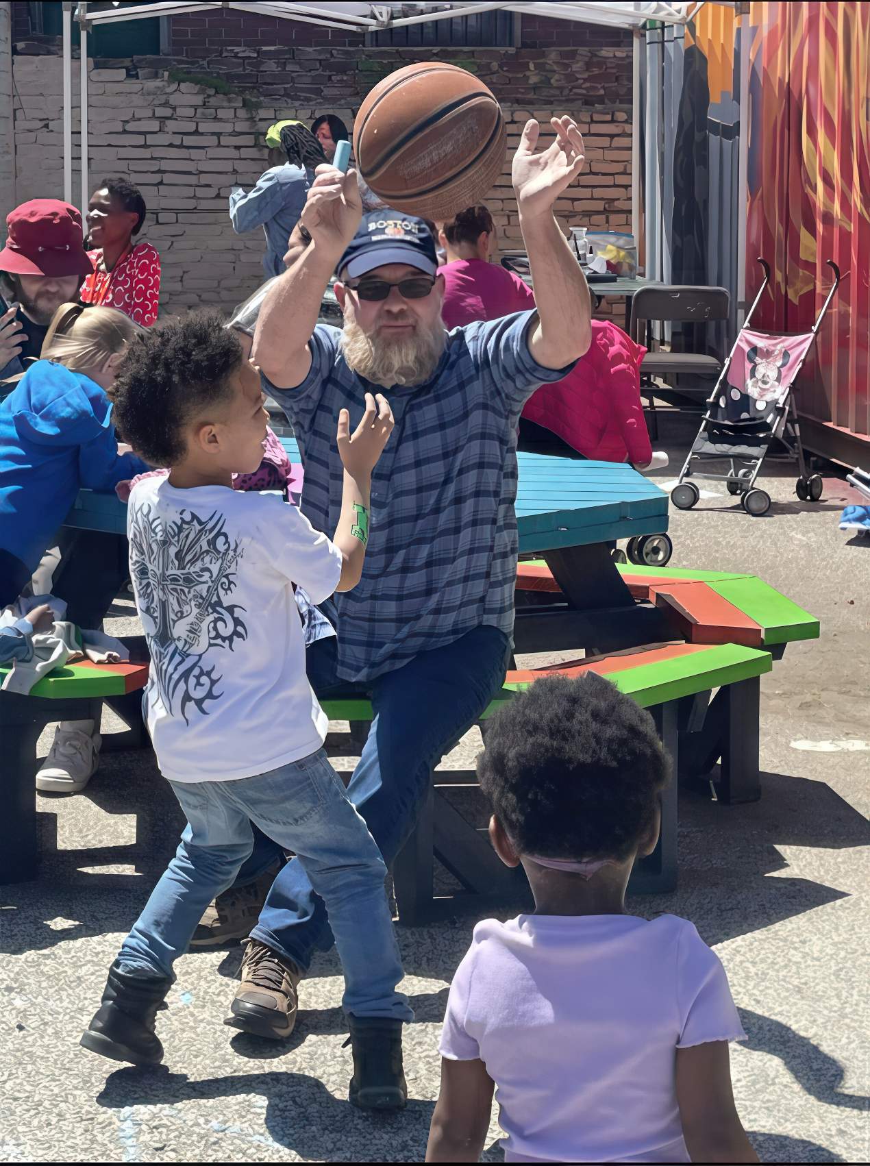 Man passing a basketball to a group of children